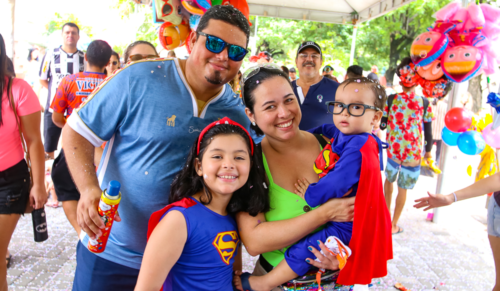 homem, mulher, filha e filho fantasiados sorrindo para a foto